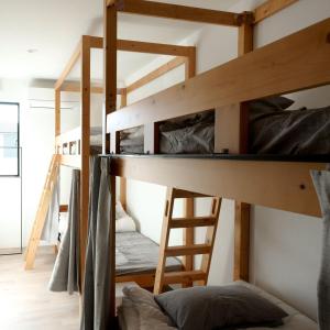Zimmer mit Etagenbett, 2 Etagenbetten und einer Leiter in der Unterkunft Matoi Hostel & Bar in Takasaki