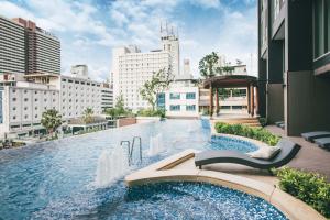 a swimming pool in the middle of a city with buildings at The Rich Residence Sukhumvit Nana in Bangkok