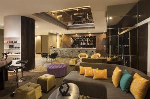 a living room with a couch and a bar at ASTON Bellevue Radio Dalam in Jakarta