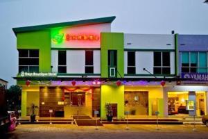 zielony i żółty budynek z restauracją w obiekcie Eight Days Boutique Hotel - Impian Emas w mieście Skudai