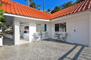 ein orangefarbenes Haus mit Stühlen und einem Tisch in der Unterkunft Kata White Villas in Kata Beach