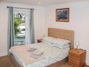 a bedroom with a bed and a window at Wherrymere in Horning