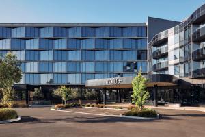 an office building with a parking lot in front of it at Mantra Melbourne Epping in Epping