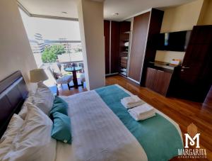 a bedroom with a large bed and a living room at Margarita Apartamentos in Cochabamba