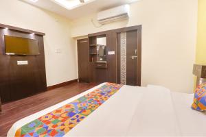 a bedroom with a bed and a door with a television at FabExpress Ambika Dx in Gwalior