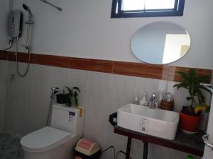 a bathroom with a toilet and a sink and a mirror at KOL House in Phnom Penh