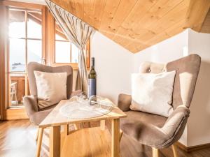 a room with two chairs and a table with a bottle of wine at Exquisite Apartment in Reith im Alpbachtal near Ski Resort and Lake in Reith im Alpbachtal