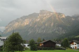 a mountain with a rainbow in front of a village at Haus Dekker in Mellau