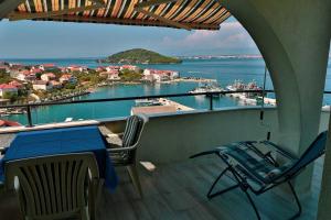 a balcony with a table and chairs and a view of the water at Apartments Novis - close to the sea in Kali