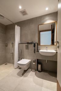 a bathroom with a sink and a toilet and a mirror at Hotel Panoramic in Ernakulam