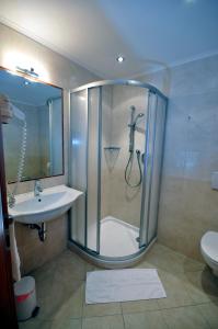 y baño con ducha y lavamanos. en Cityhotel Tallero en Bressanone