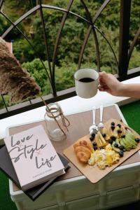 a table with a plate of food and a cup of coffee at Stunning View Boho Nova 3BR@KEA FARM, Brinchang, Cameron Highlands in Brinchang