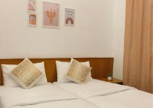 a bedroom with a bed with white sheets and pillows at Stunning View Boho Nova 3BR@KEA FARM, Brinchang, Cameron Highlands in Brinchang