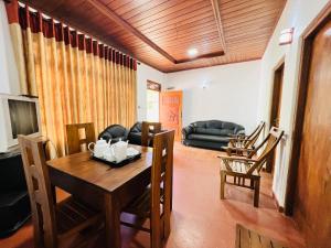a living room with a table and chairs and a couch at Allan Villa in Midigama East