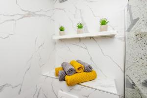 a bathroom with two towels on a yellow blanket at Apartman Angie in the centre of Metkovic in Metković