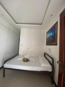 Una cama en una habitación con un arreglo floral. en WJV INN Bankal en Bankal
