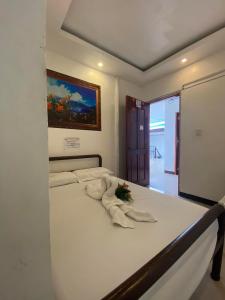 um quarto com uma cama com uma flor em WJV INN Bankal em Bankal