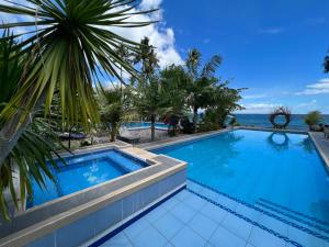 a swimming pool with a view of the ocean at Infinity Diving Resort and Residences in Dauin