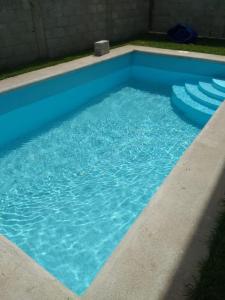 a swimming pool with blue water in a yard at Hermosa casa Tequis en Tequisquiapan in Tequisquiapan