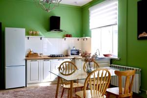 a kitchen with green walls and a table and chairs at Berry House close to Talgar Almaty in Kaynazarka