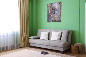 una sala de estar con sofá y una pintura en la pared en Berry House close to Talgar Almaty en Kaynazarka