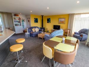 a living room with a table and chairs at Number One Bach - Kaiteriteri Holiday Home in Kaiteriteri