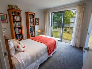 a bedroom with a bed and a large sliding glass door at Number One Bach - Kaiteriteri Holiday Home in Kaiteriteri
