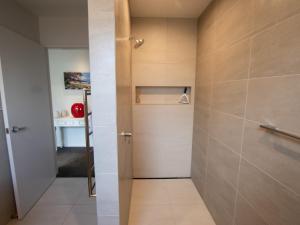 a small bathroom with a shower and a door at Number One Bach - Kaiteriteri Holiday Home in Kaiteriteri +20 photos