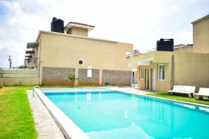 a swimming pool in front of a house at Havan Furnished Apartments-Milimani N8 in Nakuru