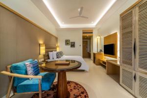 a bedroom with a bed and a table in a room at Shyama Sarovar Portico in Orai