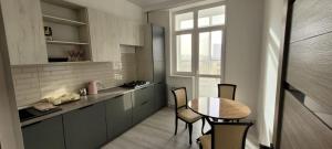 a kitchen with a table and chairs and a window at ABYROY-RESIDENCE in Atyrau