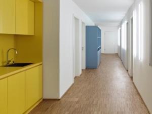 a kitchen with yellow cabinets and a wooden floor at Seminarhaus S1516 in Berlin