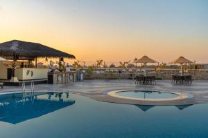 a resort with a pool with a sunset in the background at Shyama Sarovar Portico in Orai