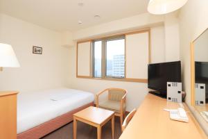 Cette chambre comprend un lit et un bureau avec un ordinateur. dans l'établissement Smile Hotel Nara, à Nara