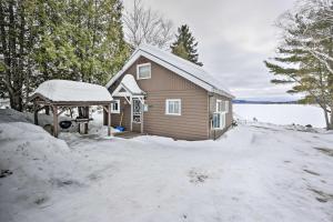 une maison avec de la neige devant elle dans l'établissement Cozy Maine Lakefront Cabin Rental, à Madawaska
