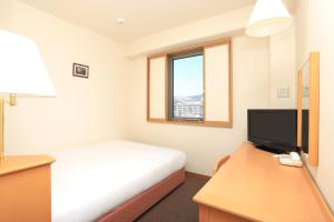 a bedroom with a bed and a desk with a television at Smile Hotel Nara in Nara +19 photos