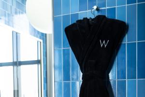 a black robe hanging on the wall of a bathroom at W Osaka in Osaka