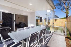a dining room with a table and chairs at 11 Ann Street in Coolum Beach