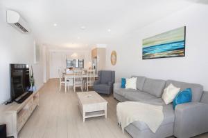 a living room with a couch and a table at Unit 406 Drift in Coolum Beach
