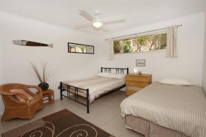 a bedroom with two beds and a chair and a window at 35 Santa Monica Avenue in Coolum Beach