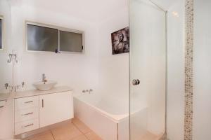 a white bathroom with a shower and a sink at 35 Santa Monica Avenue in Coolum Beach +9 photos