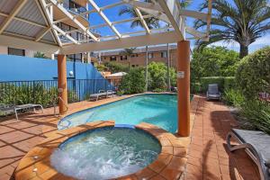 een zwembad met een pergola naast een gebouw bij Unit 8 Bronte of Coolum in Coolum Beach