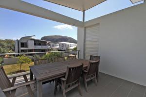 a wooden table and chairs on a balcony with a view at 48 Boardrider Crescent in Marcoola