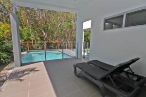 a patio with a chair and a swimming pool at 48 Boardrider Crescent in Marcoola