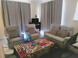 a living room with a couch and two chairs at 2BR house in West Lamington in Kalgoorlie