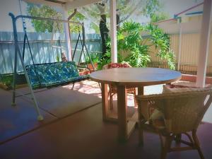a patio with a table and chairs on a porch at 2BR house in West Lamington in Kalgoorlie