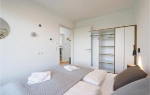 a white bedroom with a bed and a mirror at Nice Apartment In Lembruchdümmer See in Lembruch