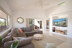 ein Wohnzimmer mit einem Sofa und einem TV in der Unterkunft Stunning Home With Spectacular Views in Coolum Beach