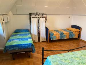 シラクーサにあるTolomei House Holidays Sea Viewのベッド2台が備わるウッドフロアの客室です。