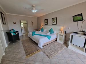 a bedroom with a large bed and a television at Glenfinnan Guest House in Langebaan